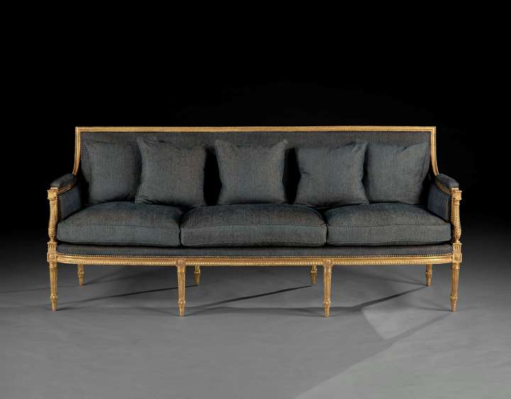 A rare suite of giltwood furniture, comprising a pair of armchairs and a long sofa
